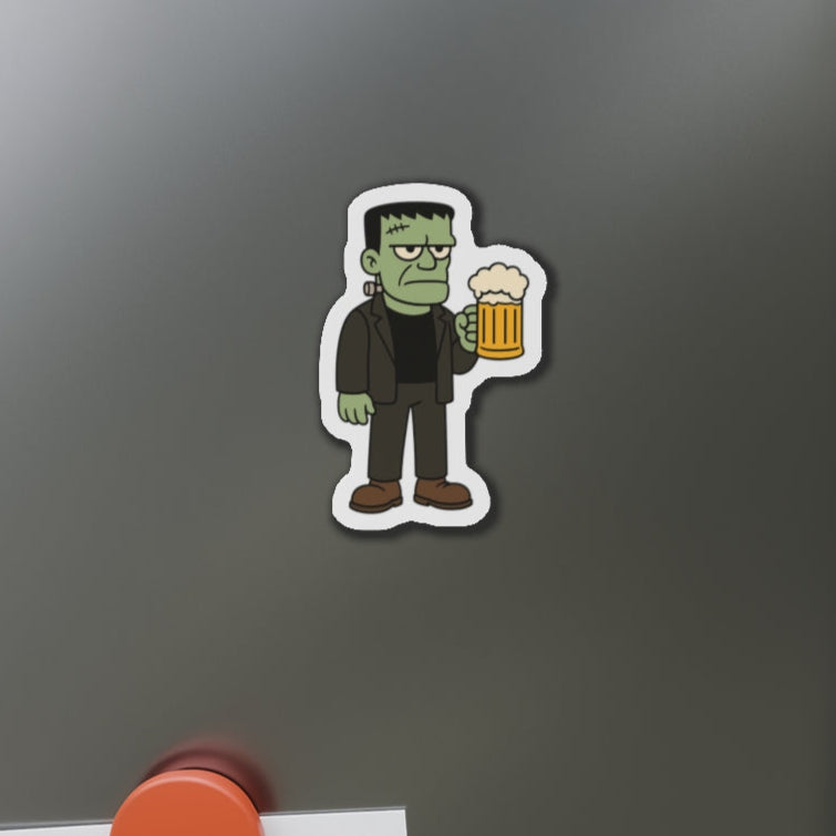 Fridge magnet of a cartoonish monster holding a beer on a metallic surface.